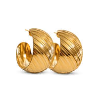 A pair of large, polished gold huggie hoop earrings with a distinctive ribbed, fluted texture, shown on a clean white background.