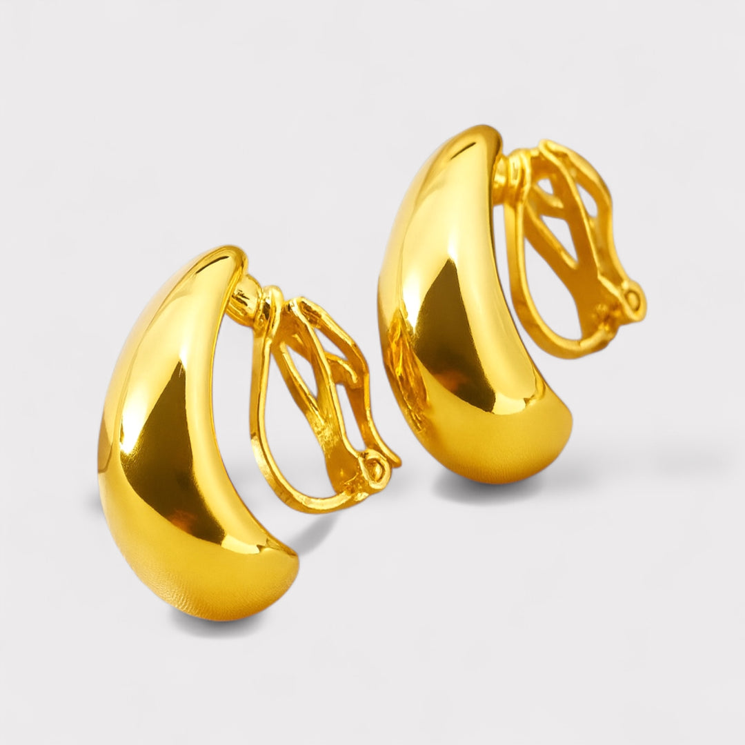 Pair of gold hoop earrings on a light gray background
