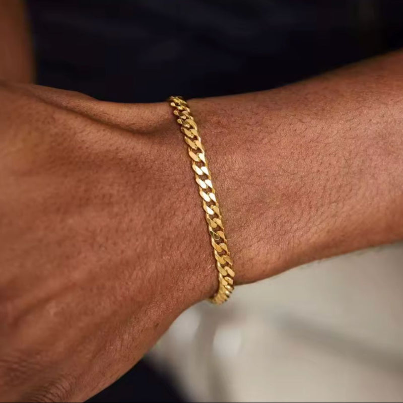 Gold chain bracelet on a wrist with a blurred background
