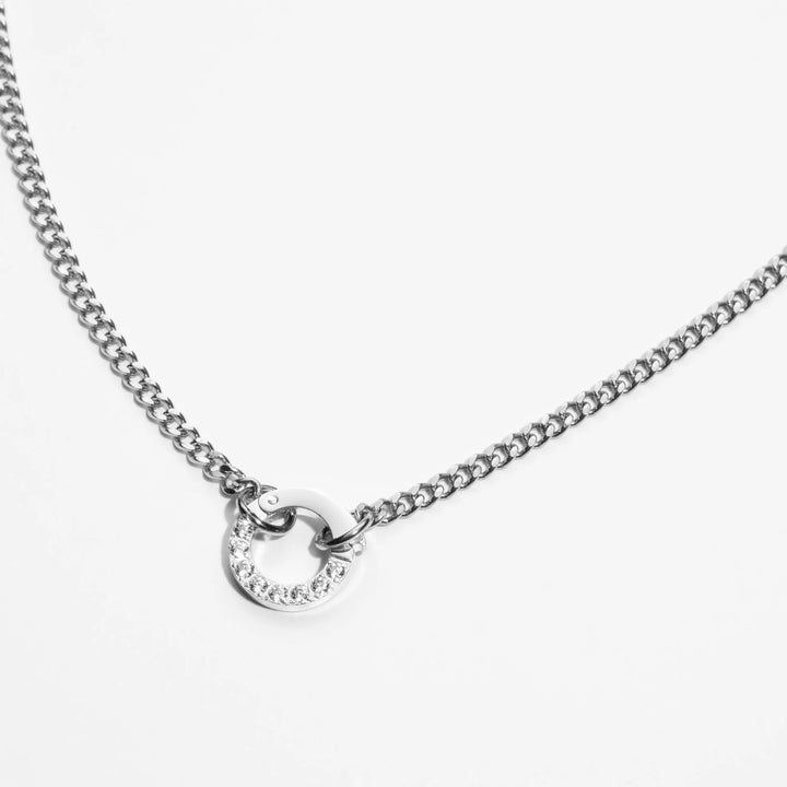 Silver necklace with a small circular pendant on a white background