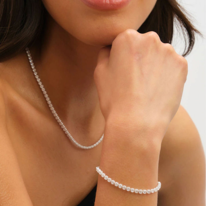Pearl necklace and bracelet on a person against a neutral background