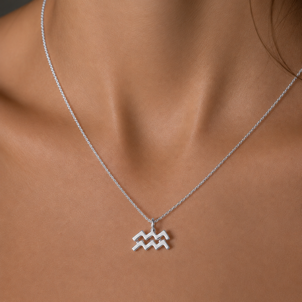 Silver Aquarius zodiac necklace on a person's neck against a neutral background