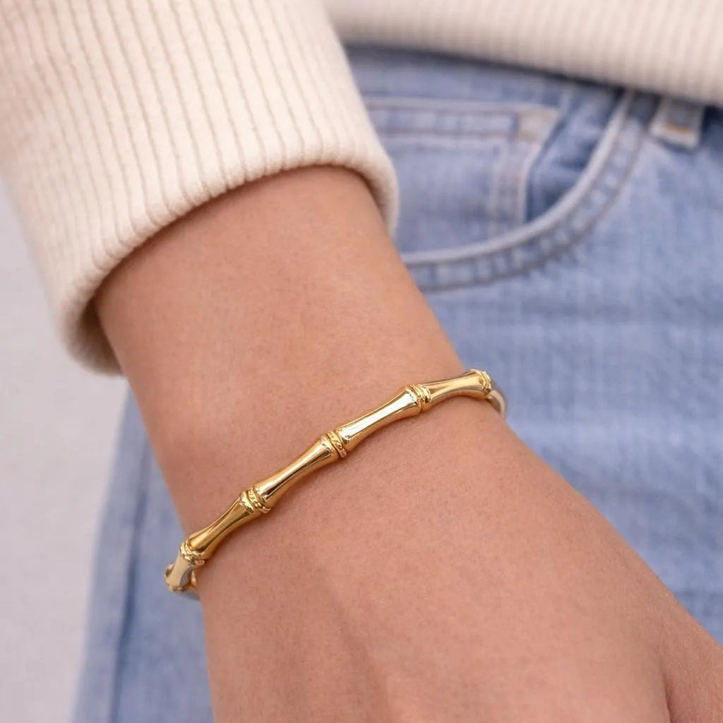 Gold bracelet on a wrist with a blurred background