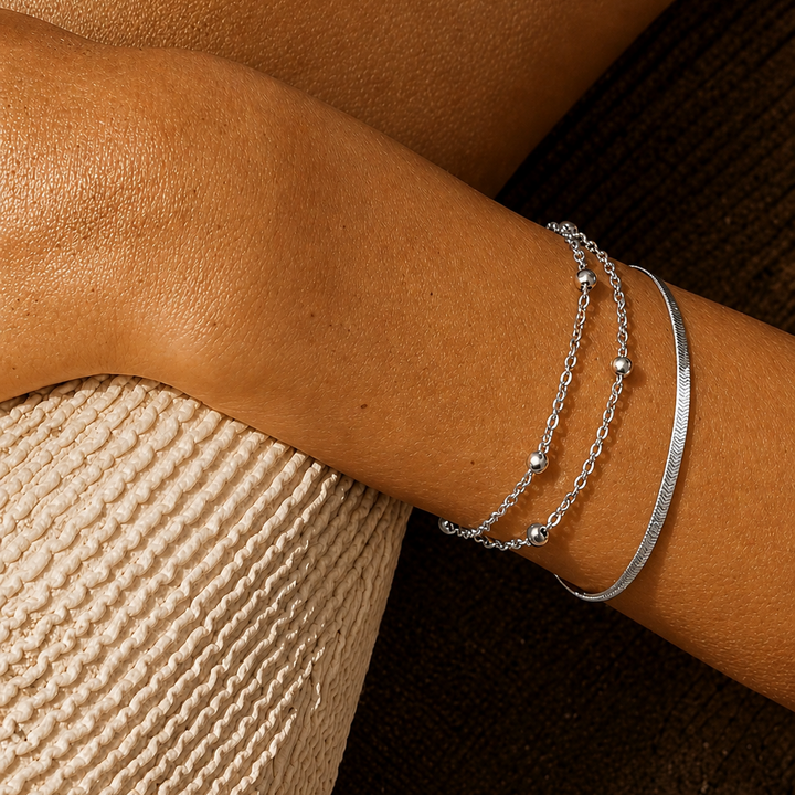 Silver bracelet on a person's wrist with a textured surface background