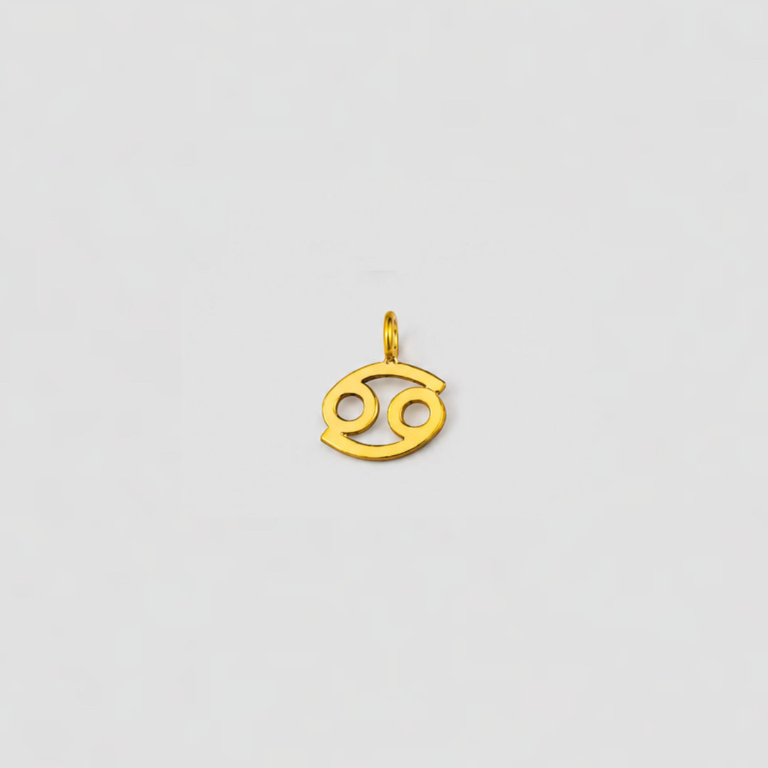 Gold Cancer zodiac pendant on a light gray background