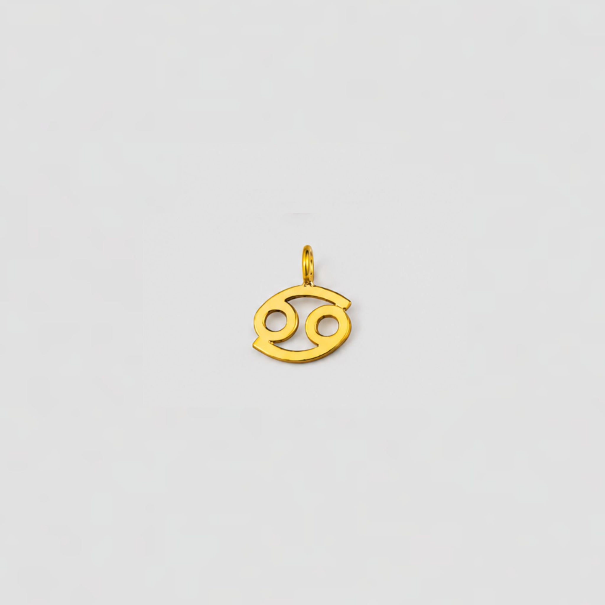 Gold Cancer zodiac pendant on a light gray background