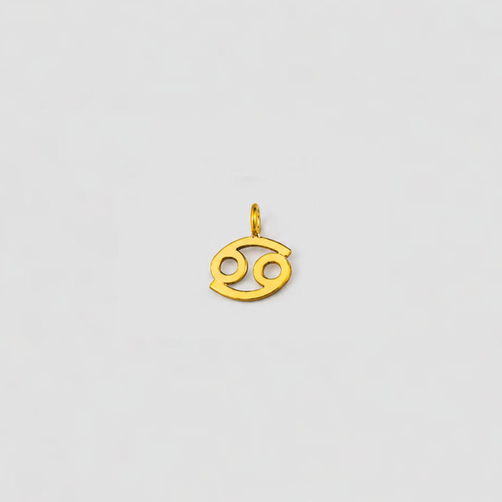 Gold Cancer zodiac pendant on a light gray background