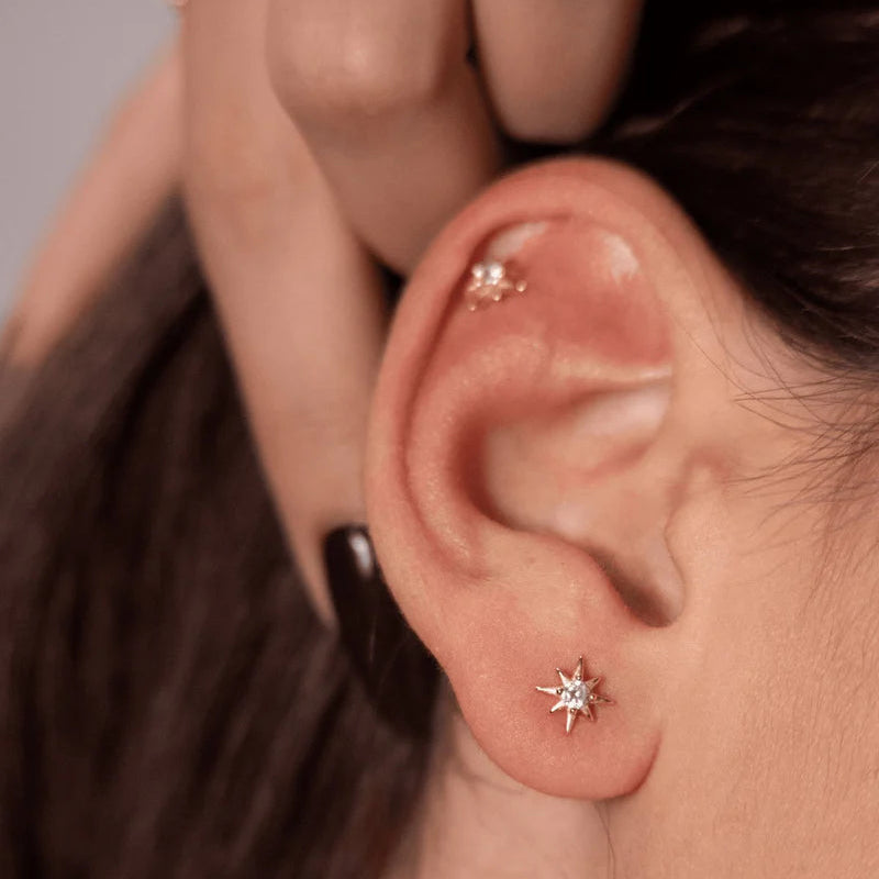 Close-up of a person wearing a star-shaped earring.