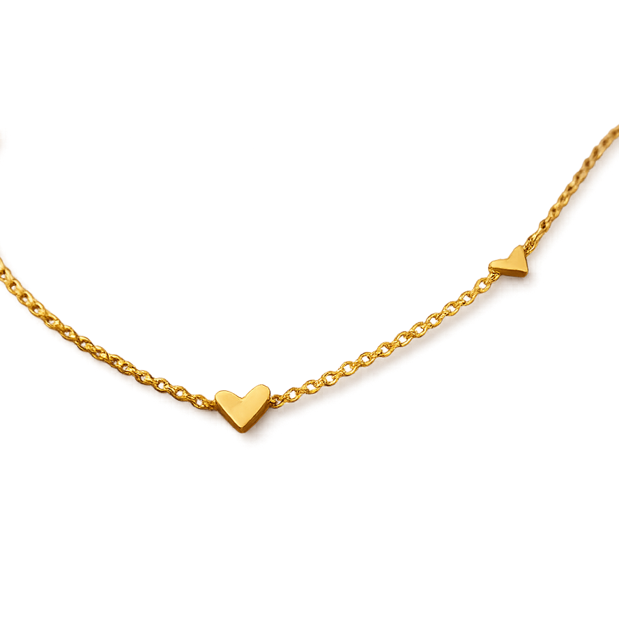 Gold necklace with heart-shaped pendant on a white background