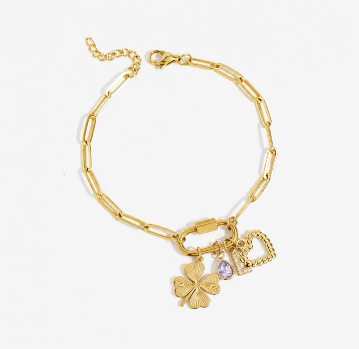 Gold bracelet with charms on a white background