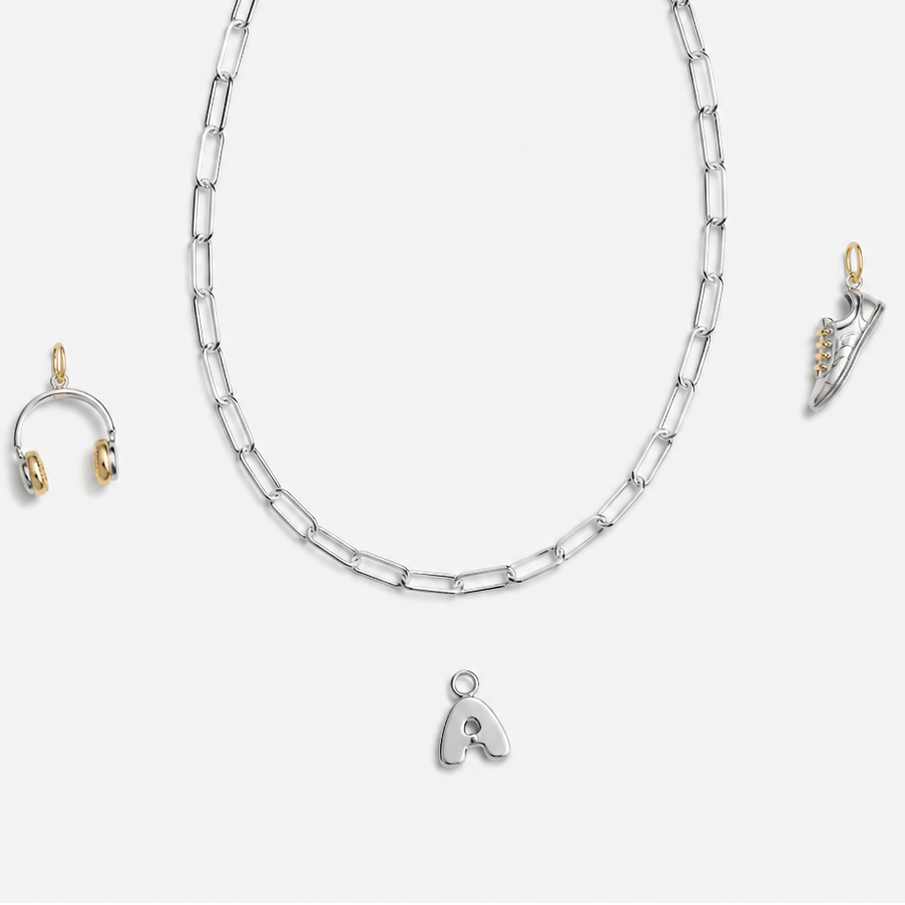 Silver necklace with a heart pendant and matching earrings on a white background