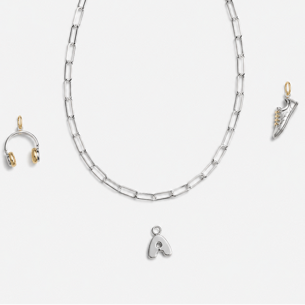 Silver necklace with a heart pendant and matching earrings on a white background