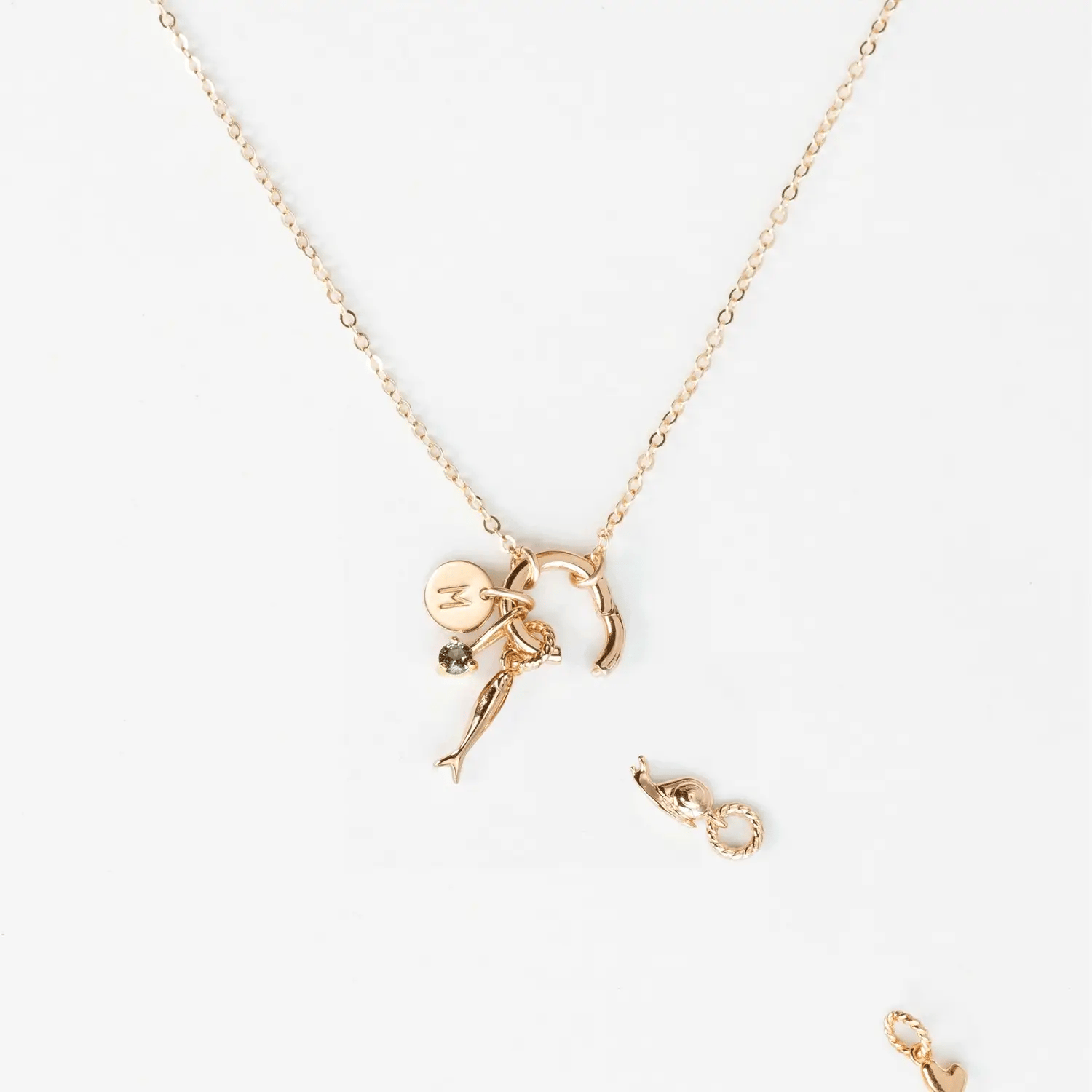 Gold necklace with a zodiac sign pendant on a white background