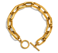 A chunky gold chain link bracelet with a toggle clasp and circular ring detail, displayed on a clean white background.