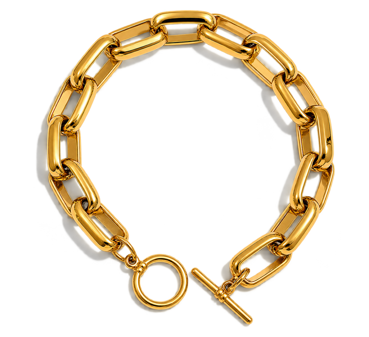 A chunky gold chain link bracelet with a toggle clasp and circular ring detail, displayed on a clean white background.