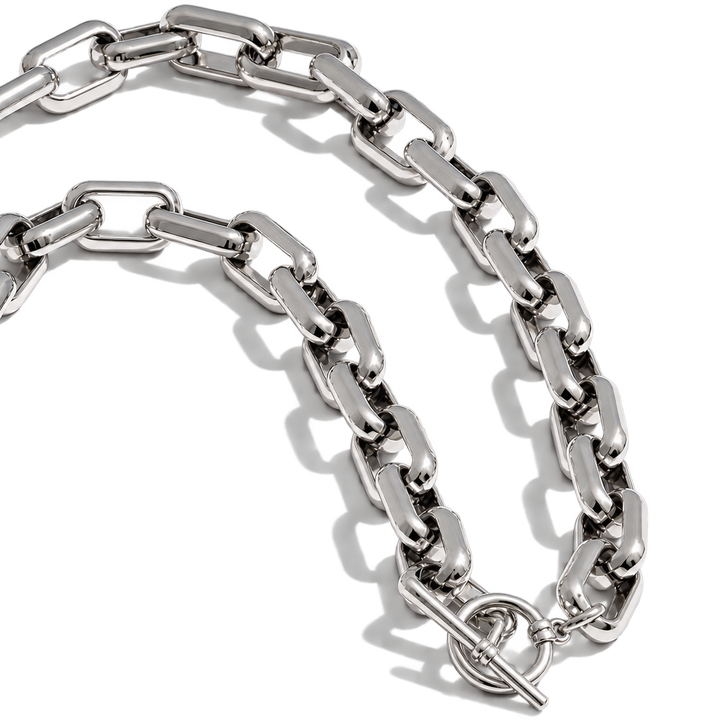A polished silver-tone metal link chain necklace with a toggle clasp, arranged in a curved loop on a clean white background.
