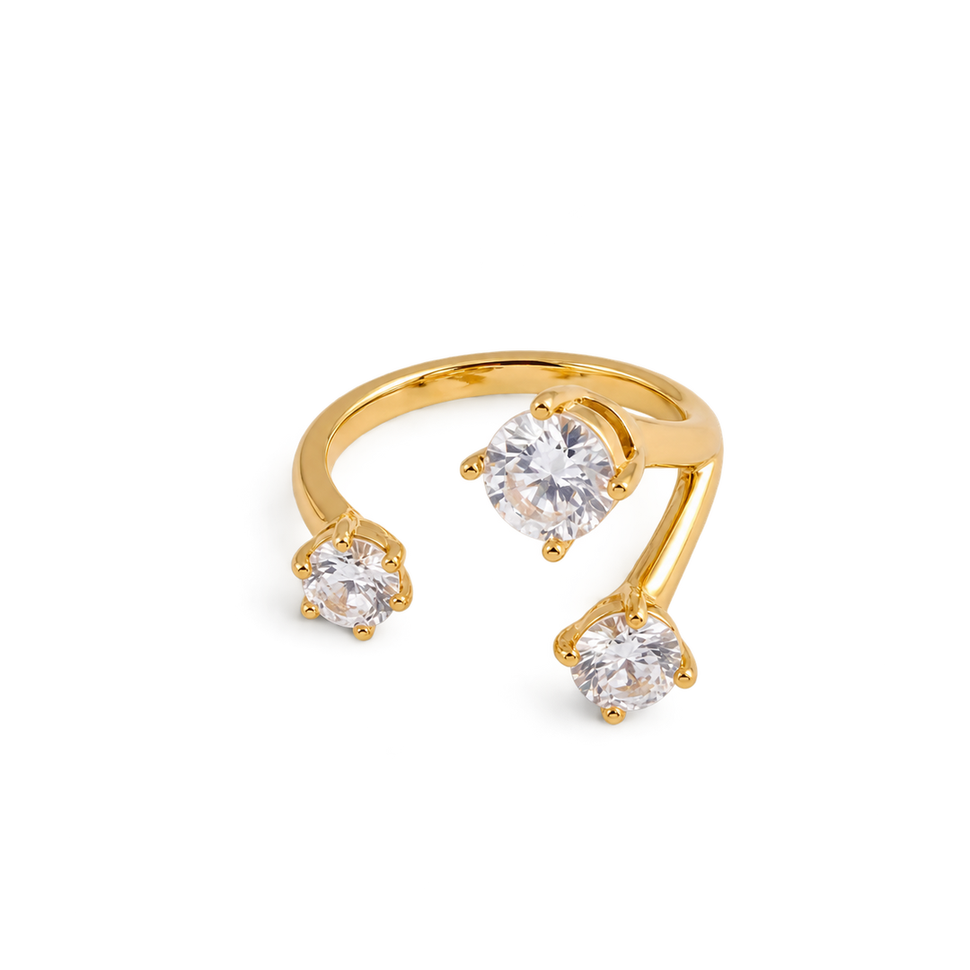 A gold open-shank ring featuring three round-cut clear gemstones in prong settings, displayed on a clean white background.