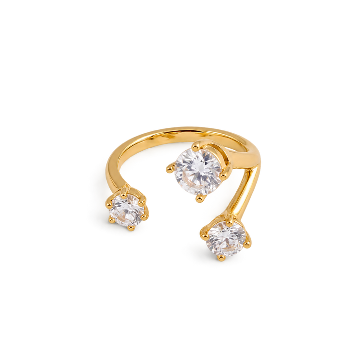 A gold open-shank ring featuring three round-cut clear gemstones in prong settings, displayed on a clean white background.