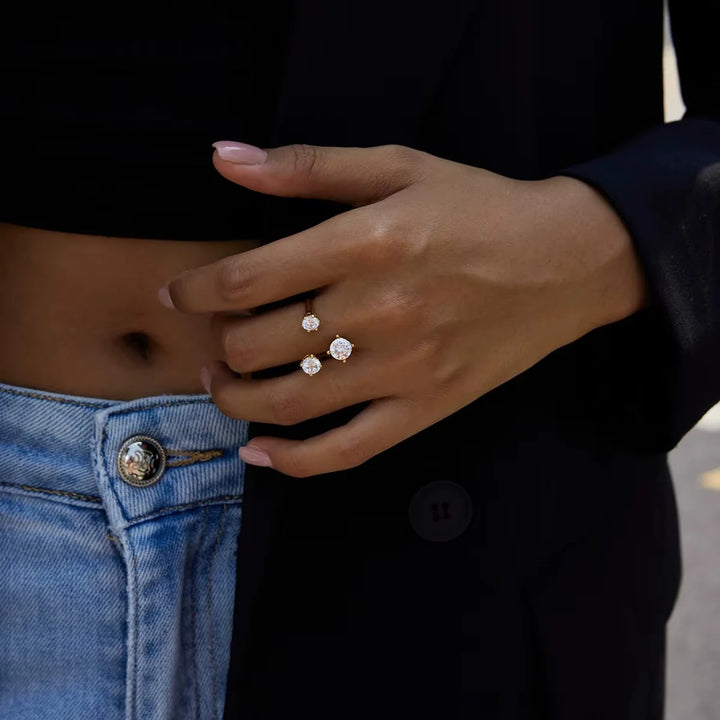 Close-up of a hand wearing two diamond rings with a blurred background