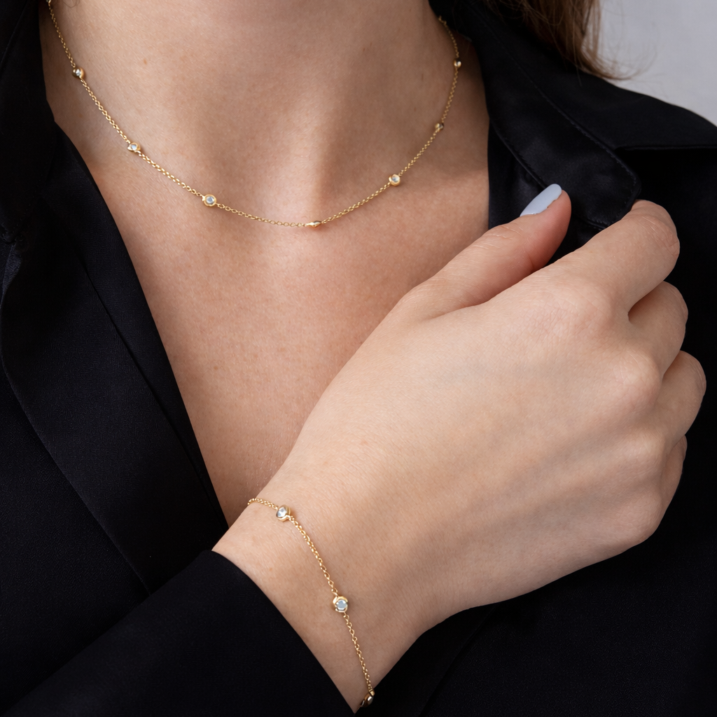 Close-up of a person wearing a delicate gold necklace and bracelet.