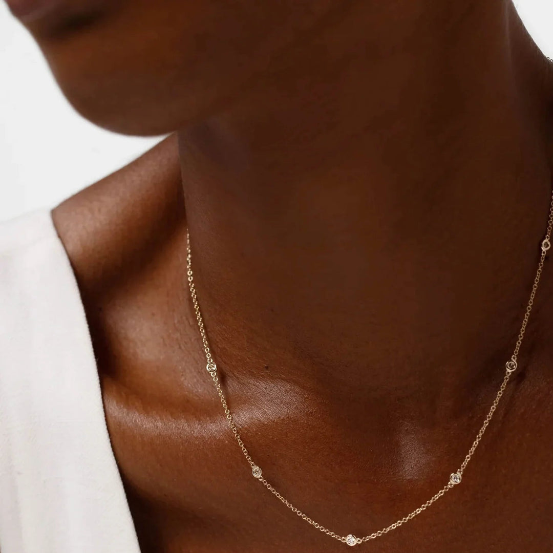 Gold necklace on a mannequin with a white sleeve