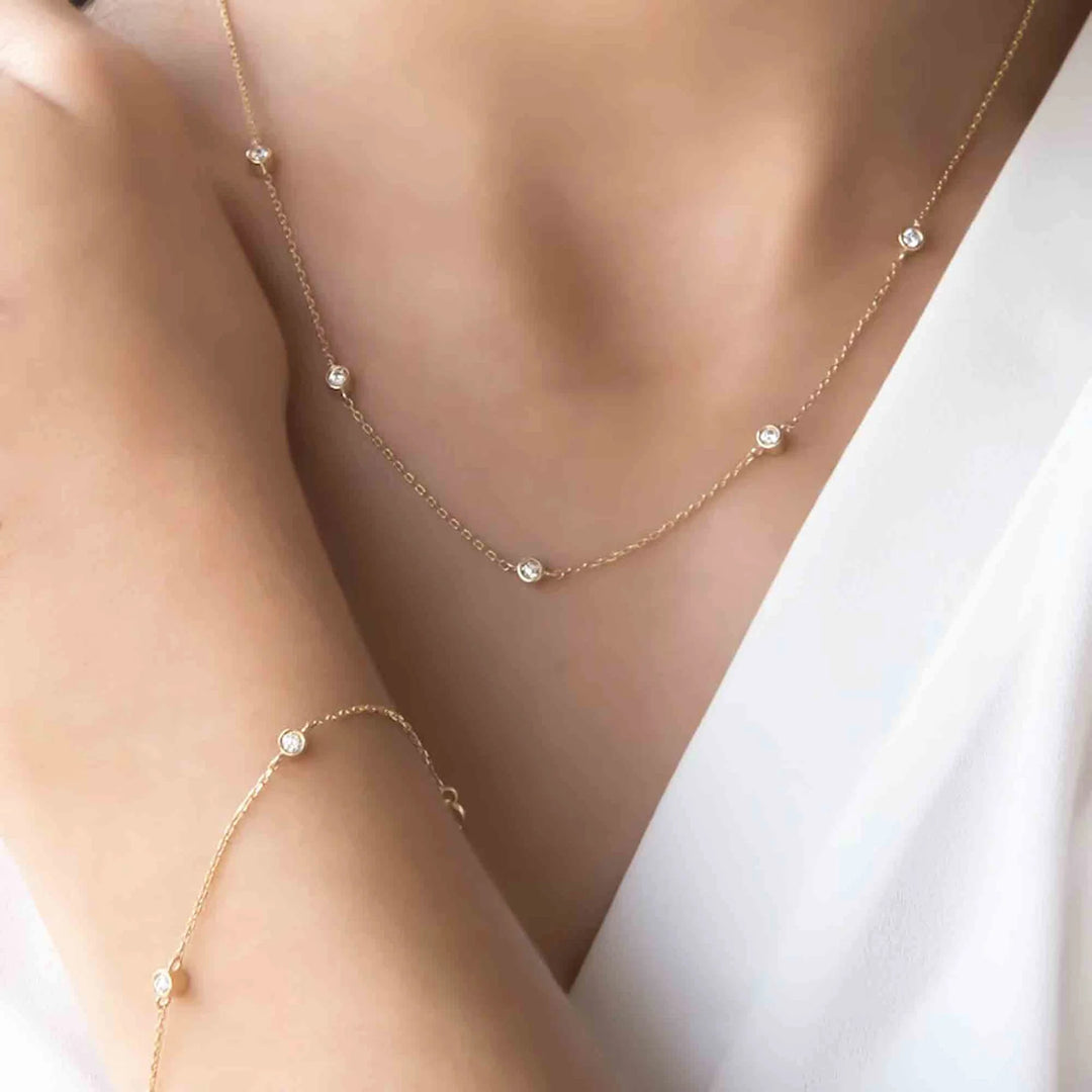 Gold necklace and bracelet set on a mannequin with a white background