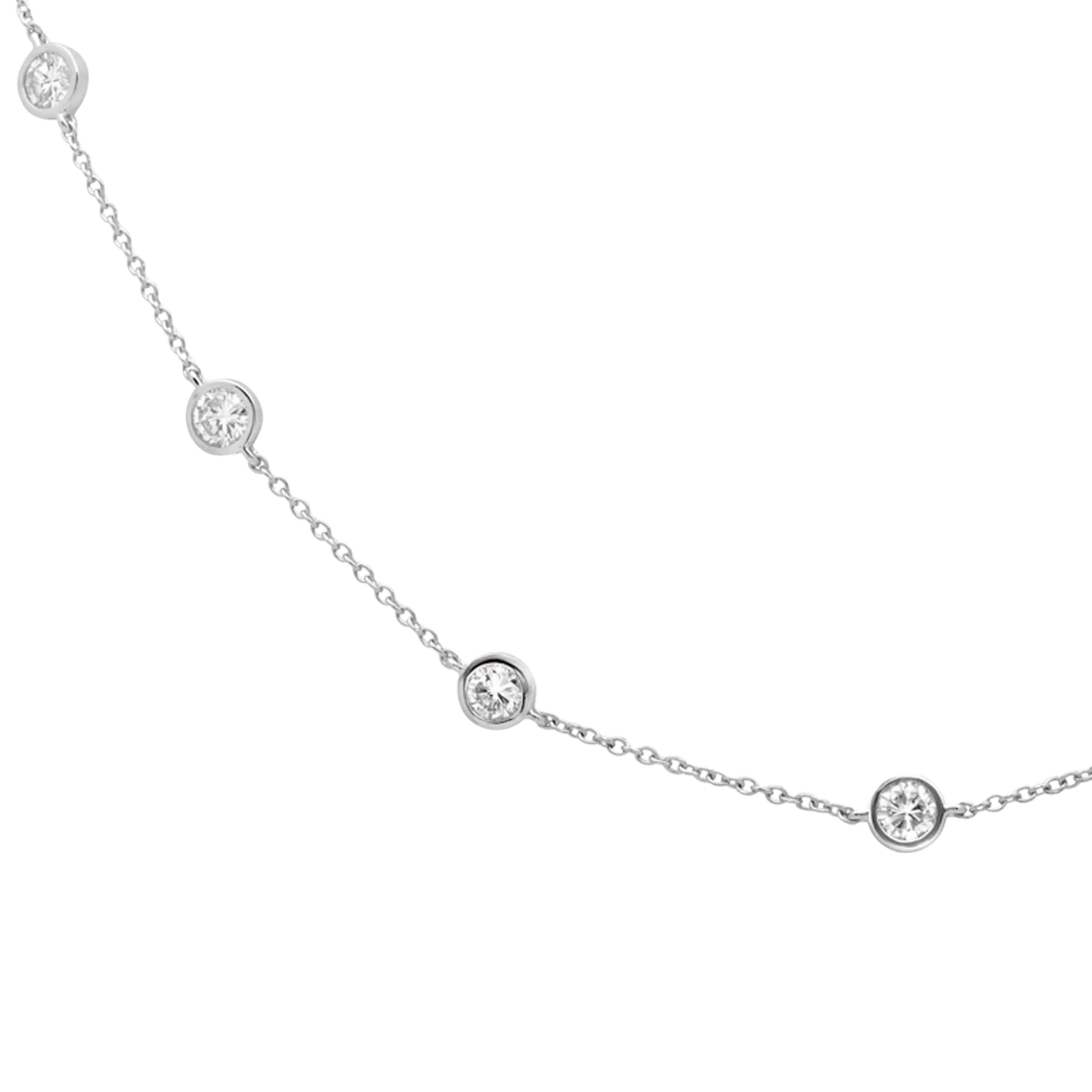 Delicate silver necklace with small round diamonds on a white background