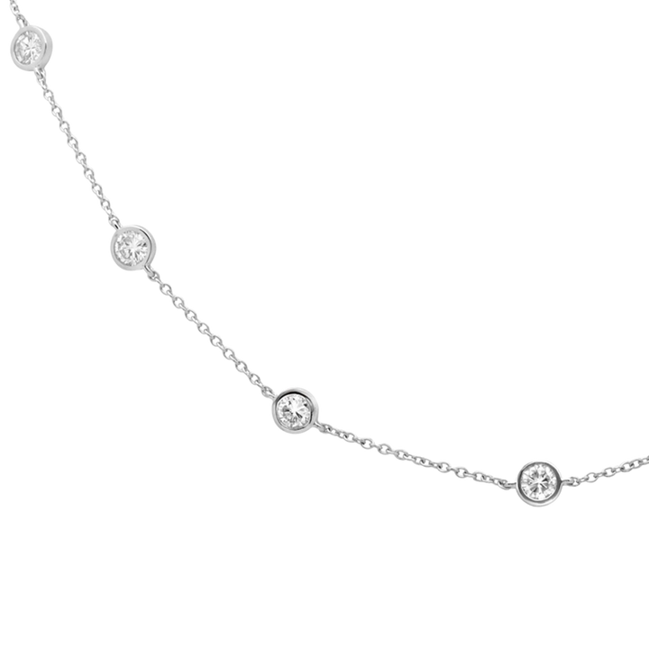 Delicate silver necklace with small round diamonds on a white background