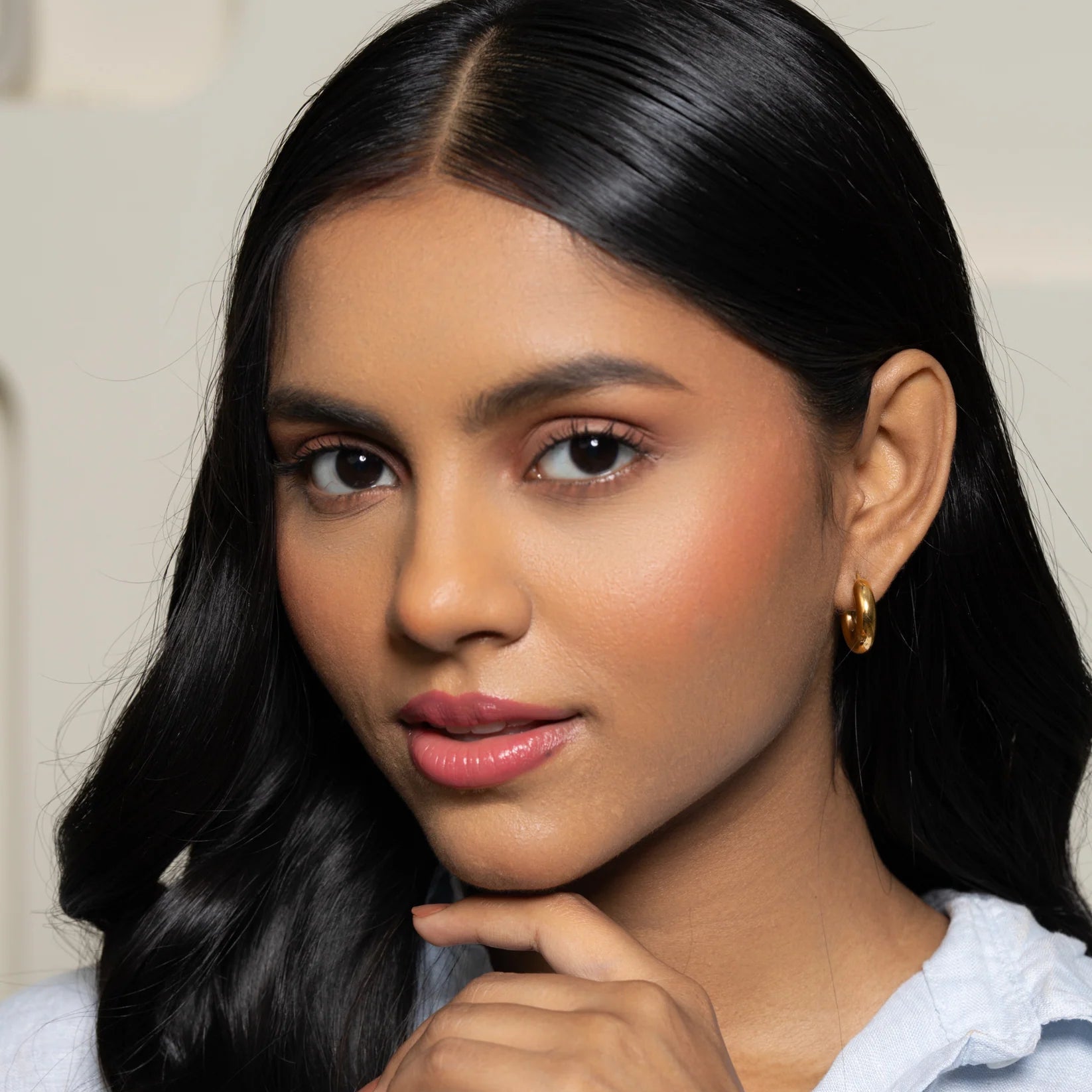 Woman with long black hair wearing a white shirt