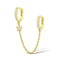 Gold hoop earrings with a chain and star detail on a white background