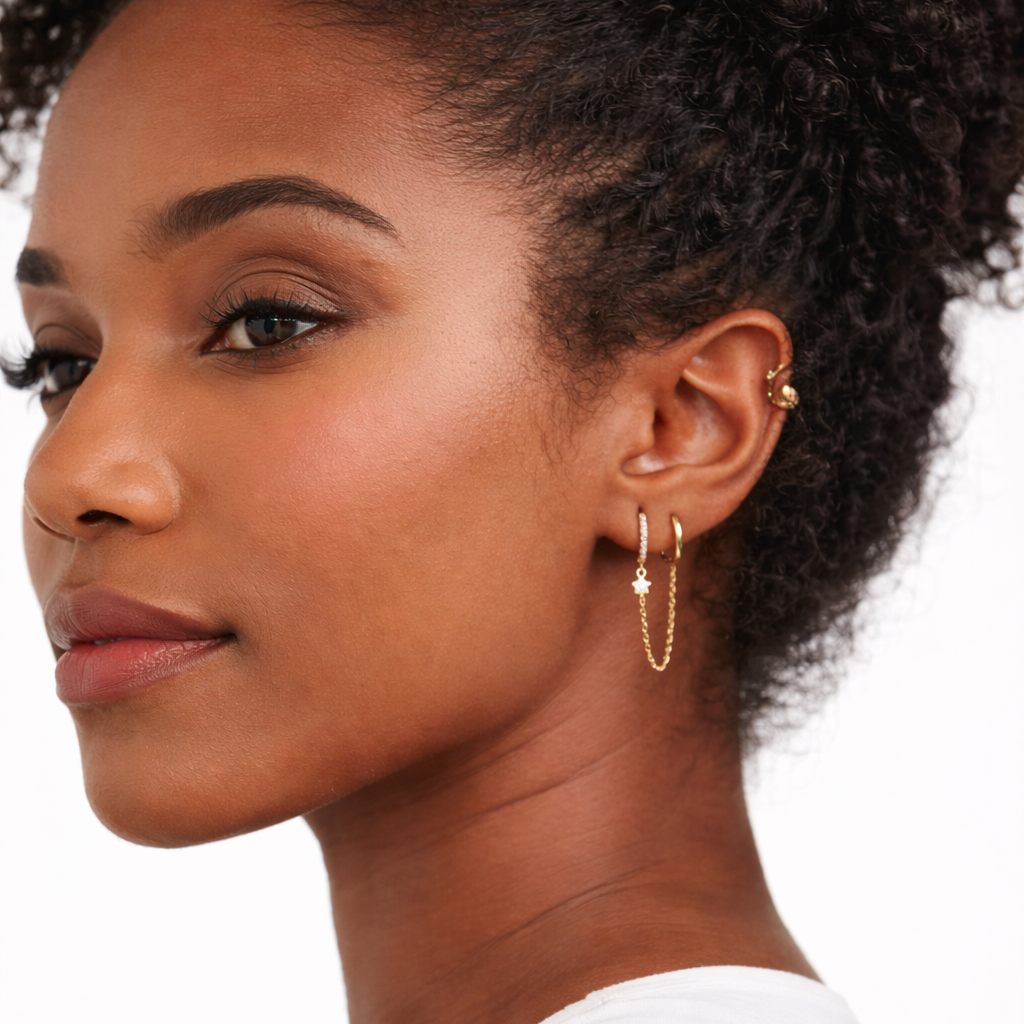 Close-up of a woman wearing gold hoop earrings with a neutral background