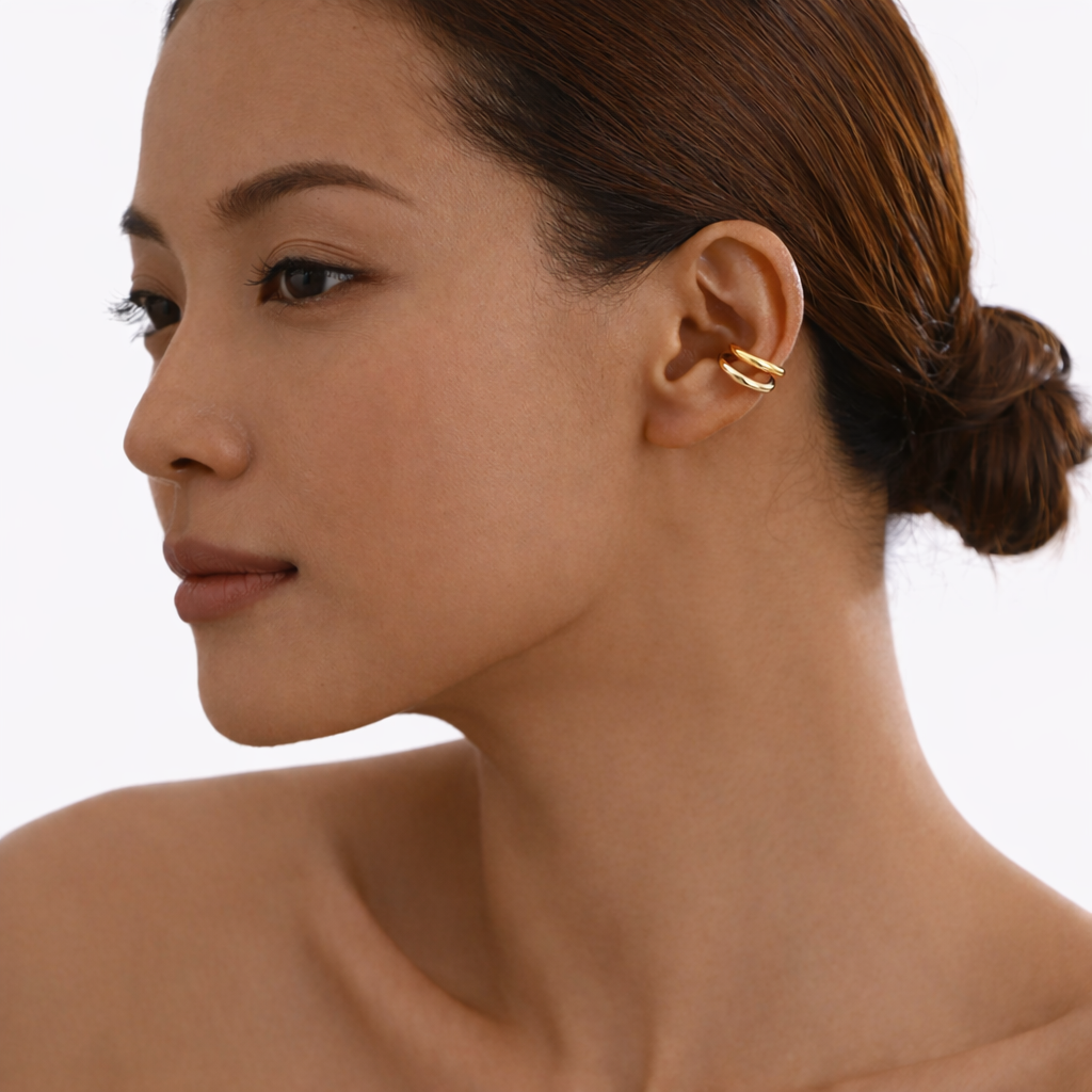 Close-up of a woman wearing a gold earring on a white background