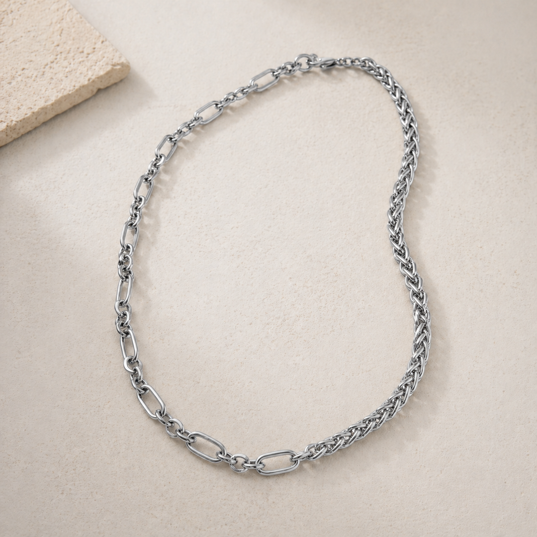 Silver chain necklace on a beige surface