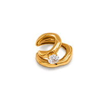 A gold ring with an organic, flowing wavy design and a single round clear gemstone, shown on a plain white background.