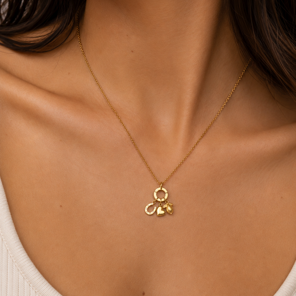 Gold necklace with a pendant on a person wearing a white top