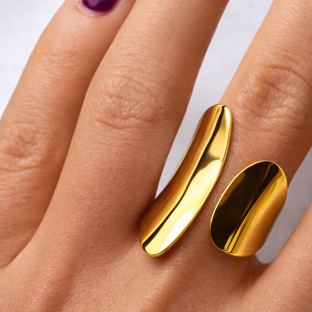 Gold ring on a person's finger with a plain background