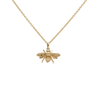 Gold bee pendant necklace on a white background
