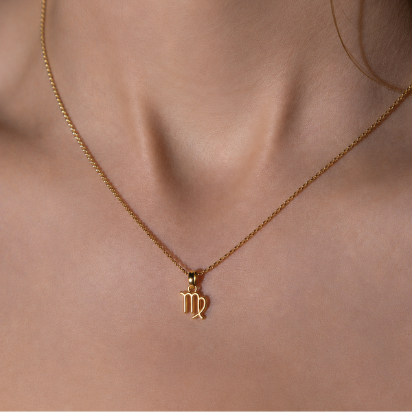Gold necklace with a virgo pendant on a person's neck 