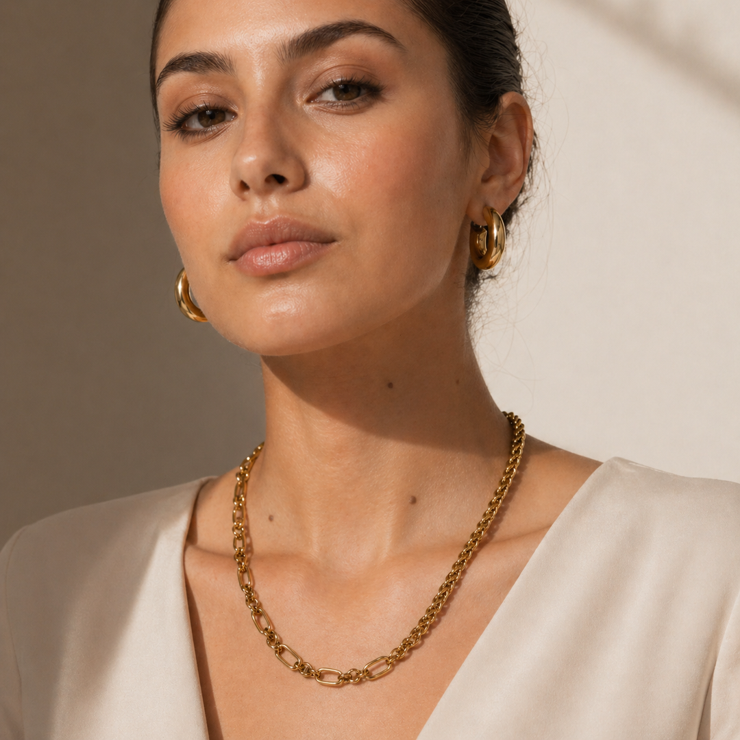 Woman wearing gold jewelry against a neutral background