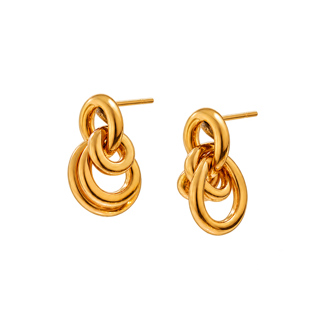 A pair of gold-toned dangle earrings with a layered, interlocking ring design and flat post backings, shown on a plain white background.