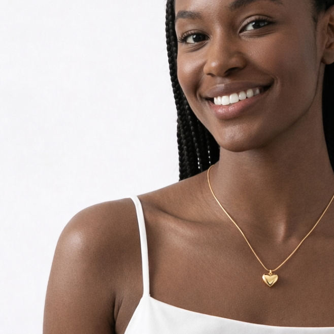 gold puffy heart necklace on model