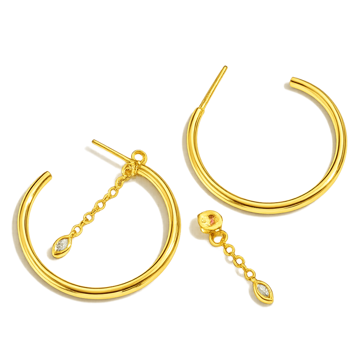 Gold hoop earrings with chain and gemstone details on a white background