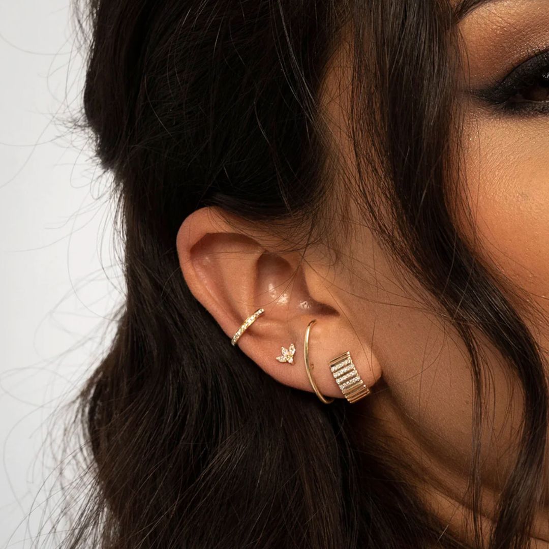 Gold earrings with diamond accents on a white background