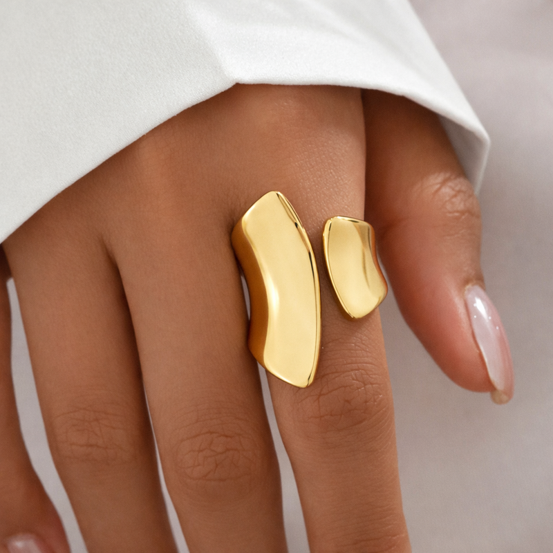 Gold ring on a finger with a neutral background