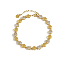 A gold-plated beaded bracelet featuring alternating flat round discs and circular settings with clear round-cut stones, displayed on a clean white background.