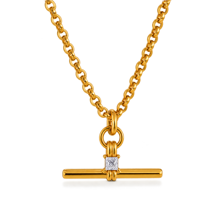 A gold chain necklace with a bar pendant featuring a square clear gemstone, shown on a clean white background.