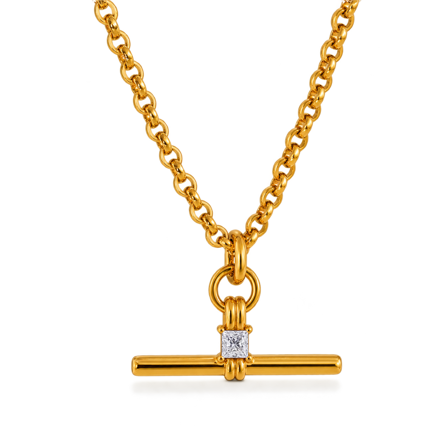 A gold chain necklace with a bar pendant featuring a square clear gemstone, shown on a clean white background.