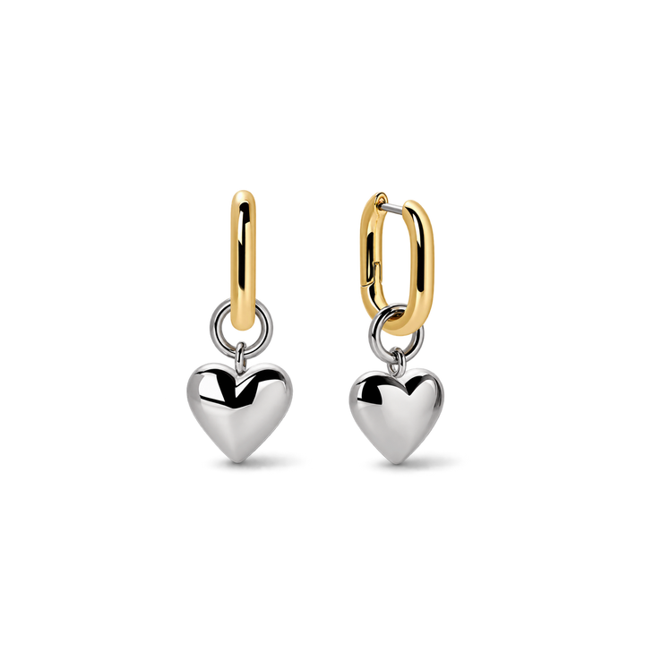 A pair of gold and silver dangle earrings on a clean white background. Each earring features a polished silver heart charm suspended from a gold huggie hoop.