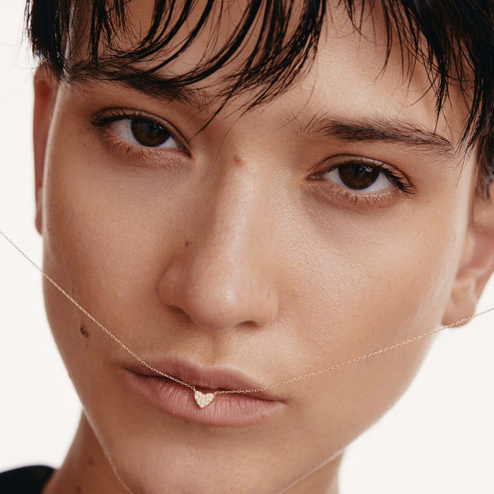 Close-up of a person with a minimalistic makeup look on a plain background