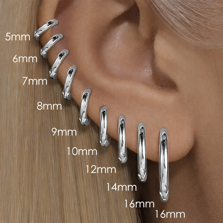 Silver hoop earrings displayed on an ear with size measurements.